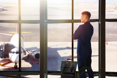 Image of Businessman with bag and travel suitcase at airport terminal. Summer vacation