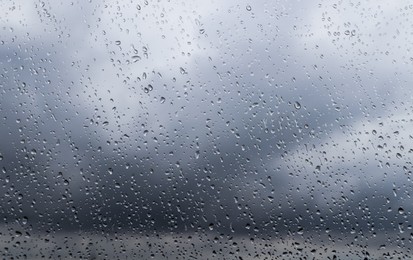 Photo of Water drops on window glass, closeup. Rainy weather