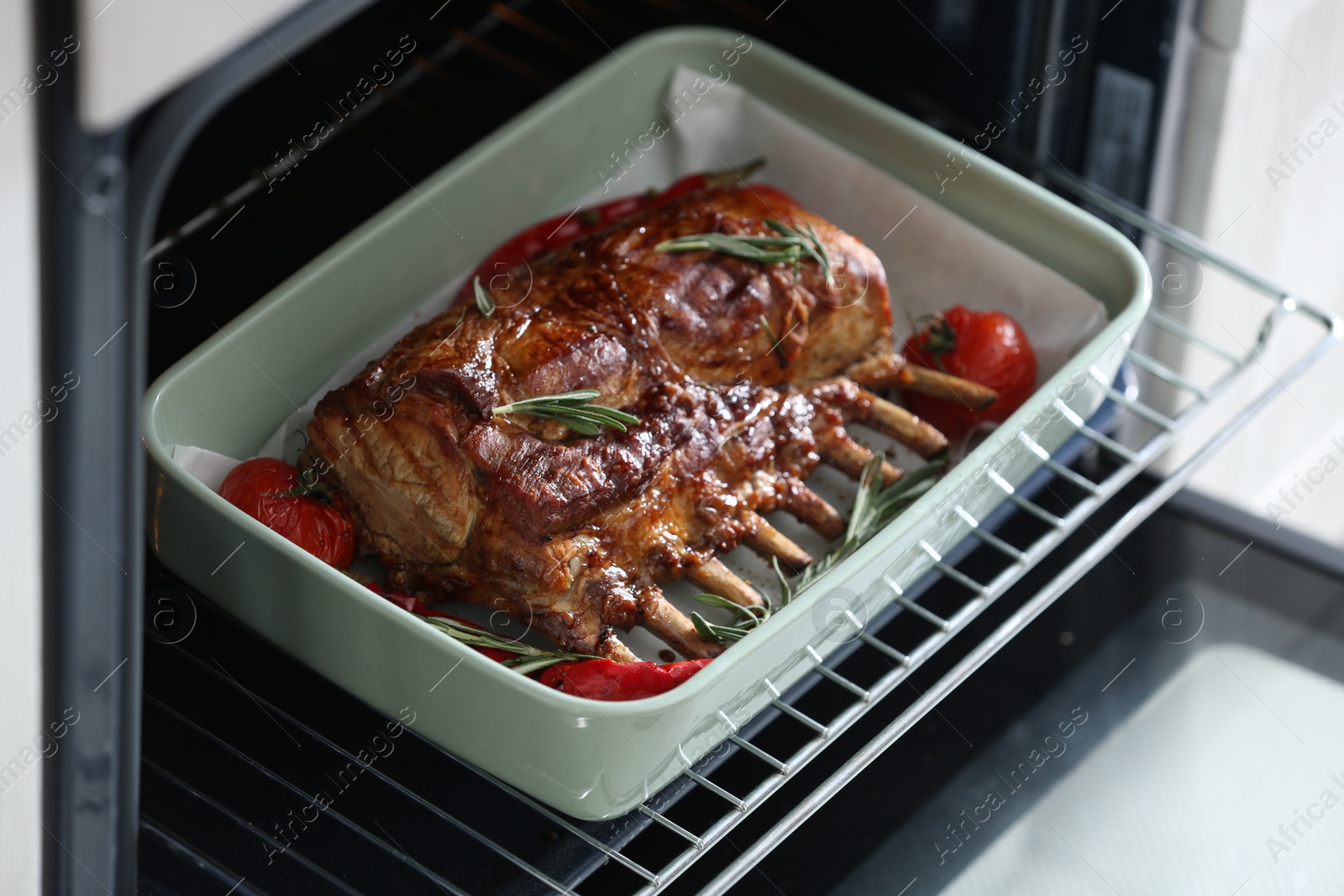 Photo of Delicious roasted ribs with tomatoes in oven