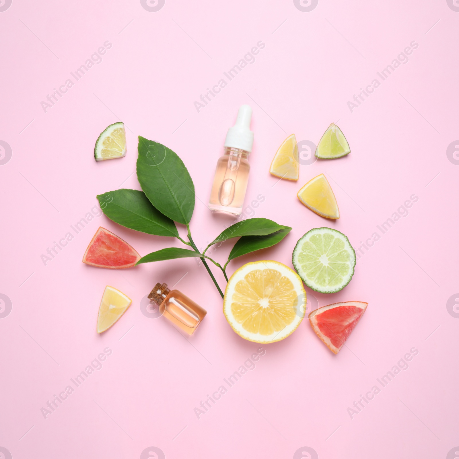 Photo of Flat lay composition with bottles of citrus essential oil on pink background