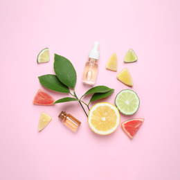 Photo of Flat lay composition with bottles of citrus essential oil on pink background