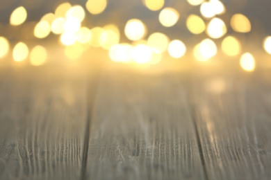 Beautiful lights on wooden table, blurred view. Space for text