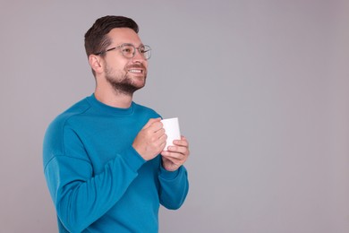 Photo of Portrait of happy man holding white mug on grey background. Space for text