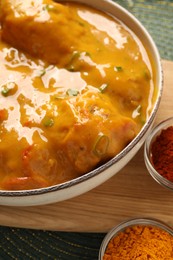 Photo of Tasty chicken curry on green place mat, closeup