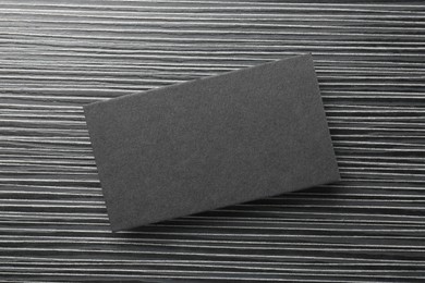 Blank black business card on wooden table, top view. Mockup for design