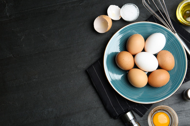 Photo of Flat lay composition with chicken eggs on black table. Space for text