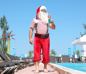 Authentic Santa Claus with cocktail near pool at resort