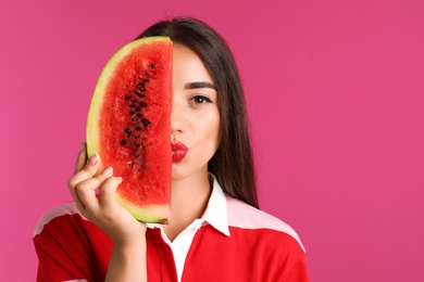 Photo of Beautiful young woman posing with watermelon on color background