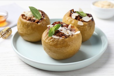 Photo of Baked apples on white wooden table, closeup