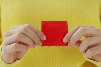 Photo of Woman holding condom, closeup view. Safe sex