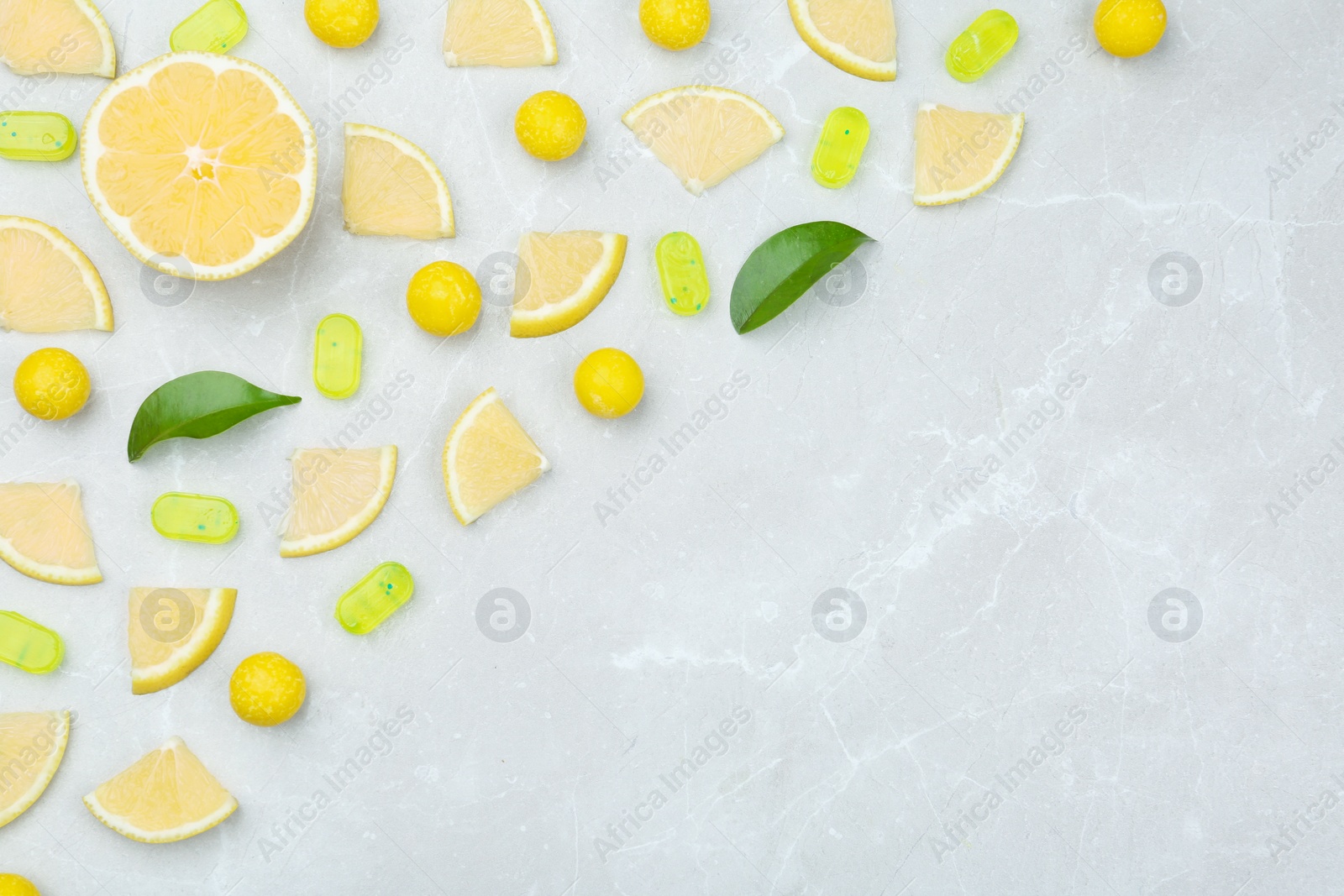 Photo of Flat lay composition with lemon drops on grey marble table. Space for text