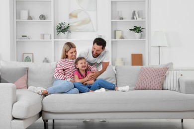 Photo of Happy family having fun together on sofa at home
