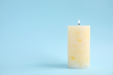 Photo of Alight wax candle on color background. Space for text