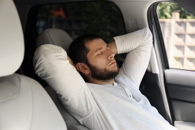 Tired man sleeping in his modern car