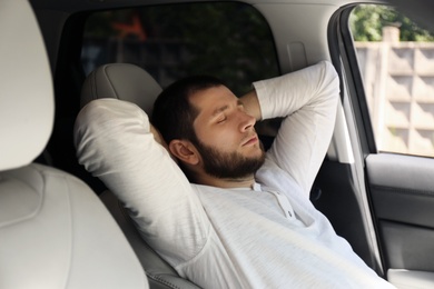 Photo of Tired man sleeping in his modern car