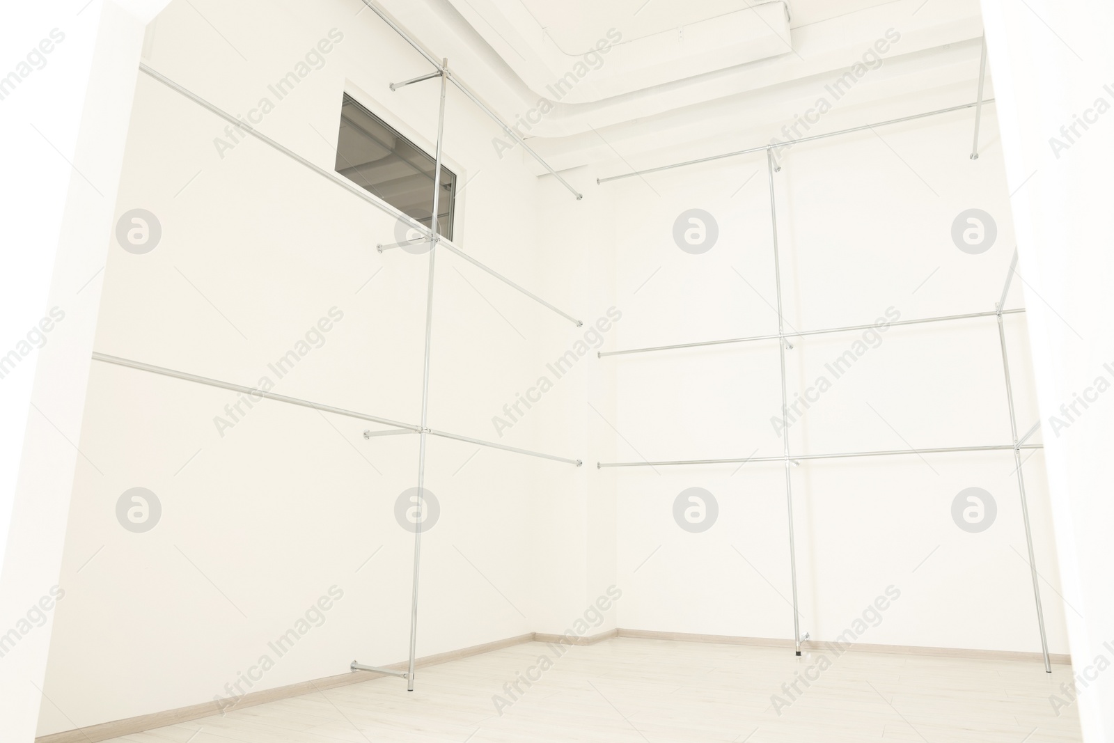 Photo of Metal pipes near white walls in empty office room. Interior design