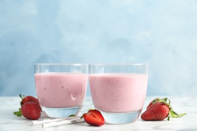 Photo of Glasses with healthy detox smoothie and strawberries on table