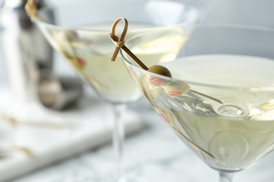 Glasses of Classic Dry Martini with olives on table, closeup