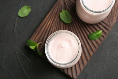 Jars with yummy yogurt on wooden board