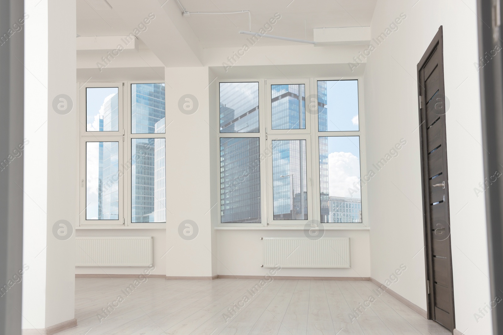 Photo of Modern office room with windows and door. Interior design