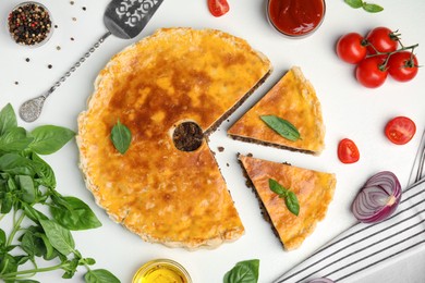 Delicious pie with minced meat and ingredients on white table, flat lay