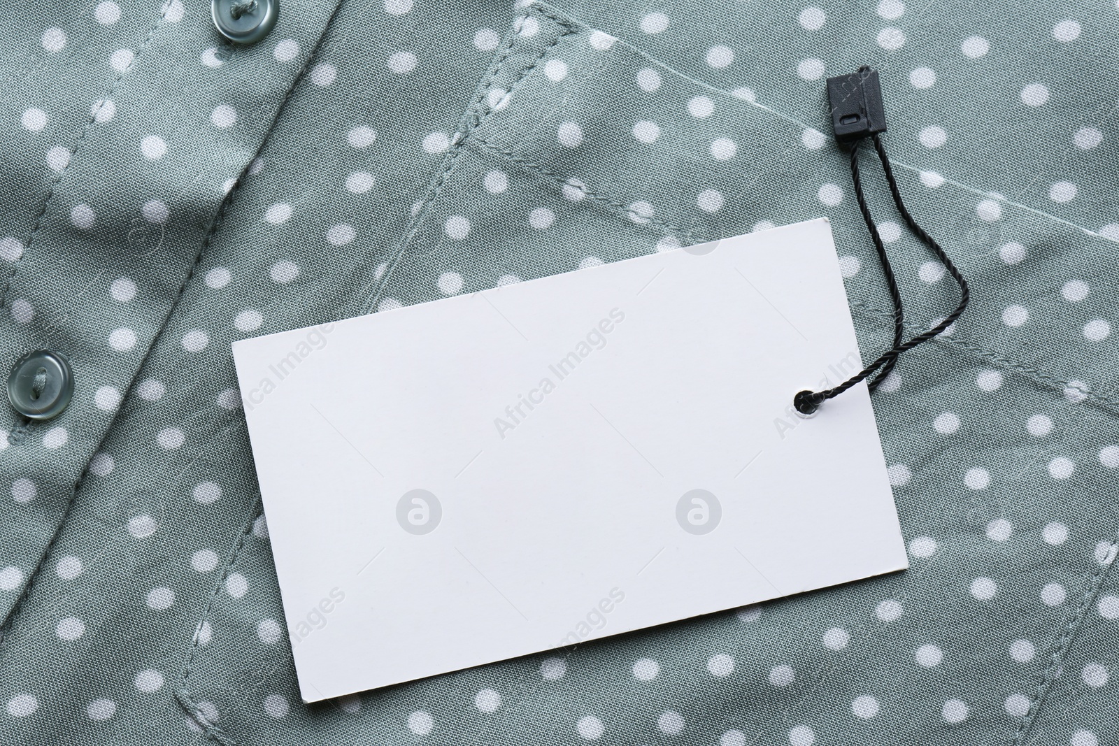 Photo of Blank tag on shirt, top view. Space for text