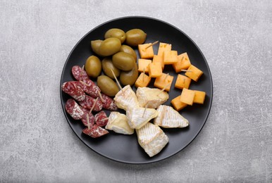 Photo of Toothpick appetizers. Pieces of cheese, sausage and olives on light grey table, top view
