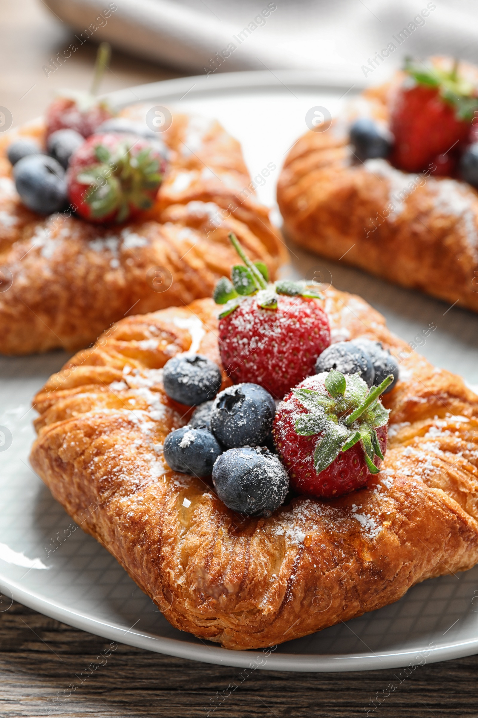 Photo of Fresh delicious puff pastry with sweet berries on table, closeup