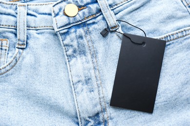 Blank tag on jeans, top view. Space for text