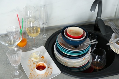 Photo of Pile of dirty dishes in kitchen after party