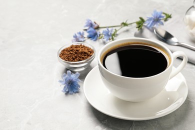 Photo of Cup of delicious chicory drink on light grey marble table, space for text