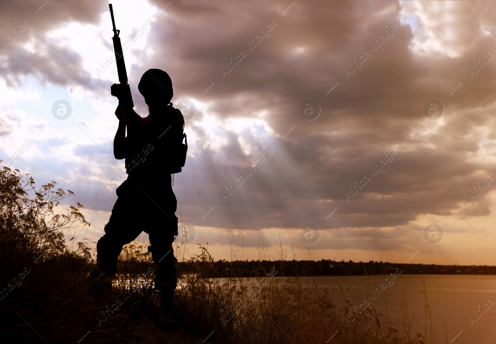 Photo of Soldier with machine gun patrolling outdoors. Military service