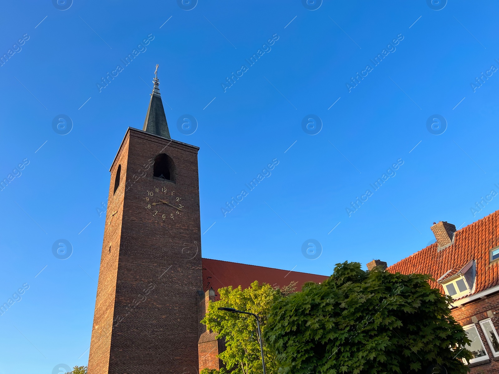 Photo of Beautiful old tower and house against blue sky, low angle view