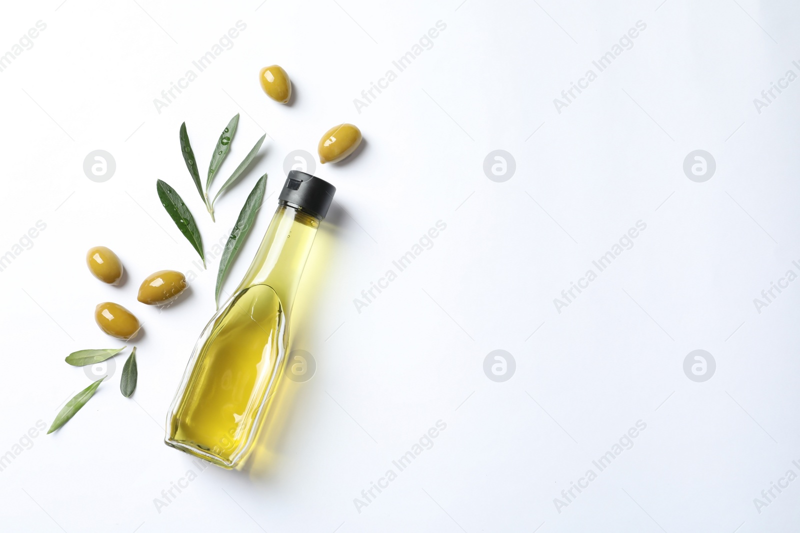 Photo of Bottle with oil and ripe olives on white background