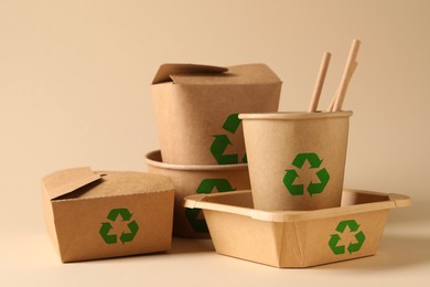 Image of Set of eco friendly food packaging with recycling symbols on beige background