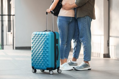 Long-distance relationship. Couple with luggage near house entrance outdoors, closeup