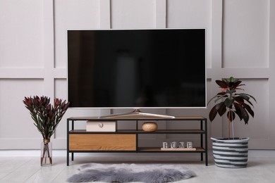 Photo of Stylish room interior with TV on wooden cabinet