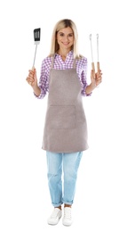 Photo of Woman in apron with barbecue utensils on white background