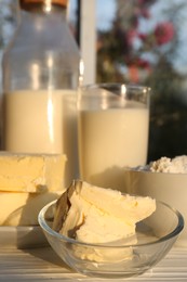 Photo of Tasty homemade butter and dairy products on white wooden windowsill