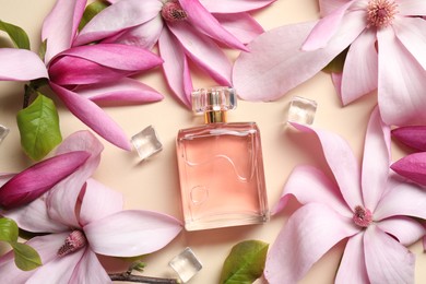 Photo of Beautiful pink magnolia flowers, bottle of perfume and ice cubes on beige background, flat lay