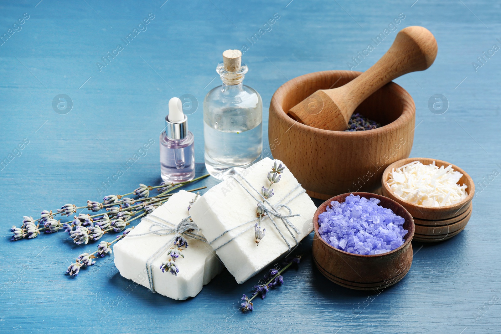 Photo of Handmade soap bars with lavender flowers and ingredients on blue wooden table