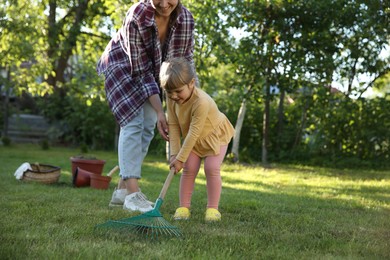 Photo of Mother and her daughter working together in garden