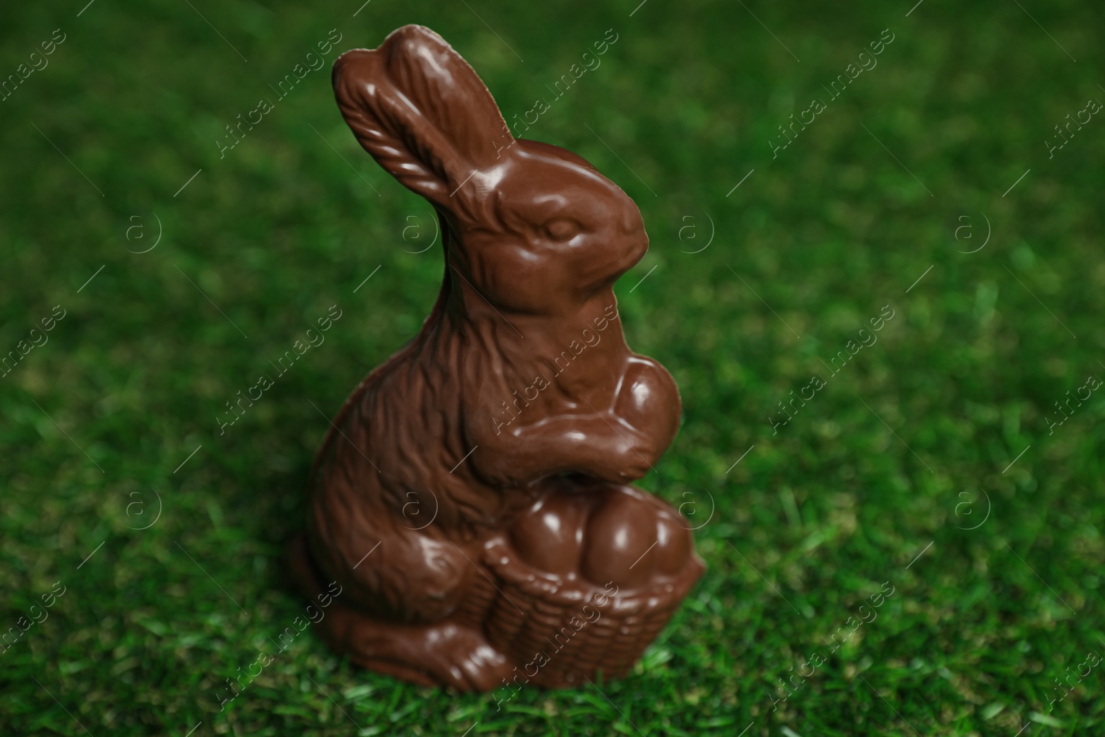 Photo of Chocolate bunny on green grass. Easter celebration