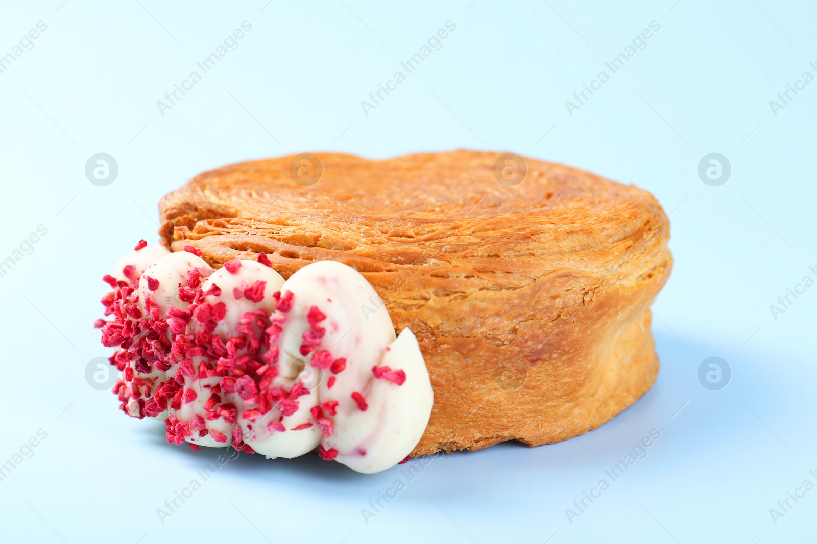 Photo of One supreme croissant with cream on light blue background, closeup. Tasty puff pastry