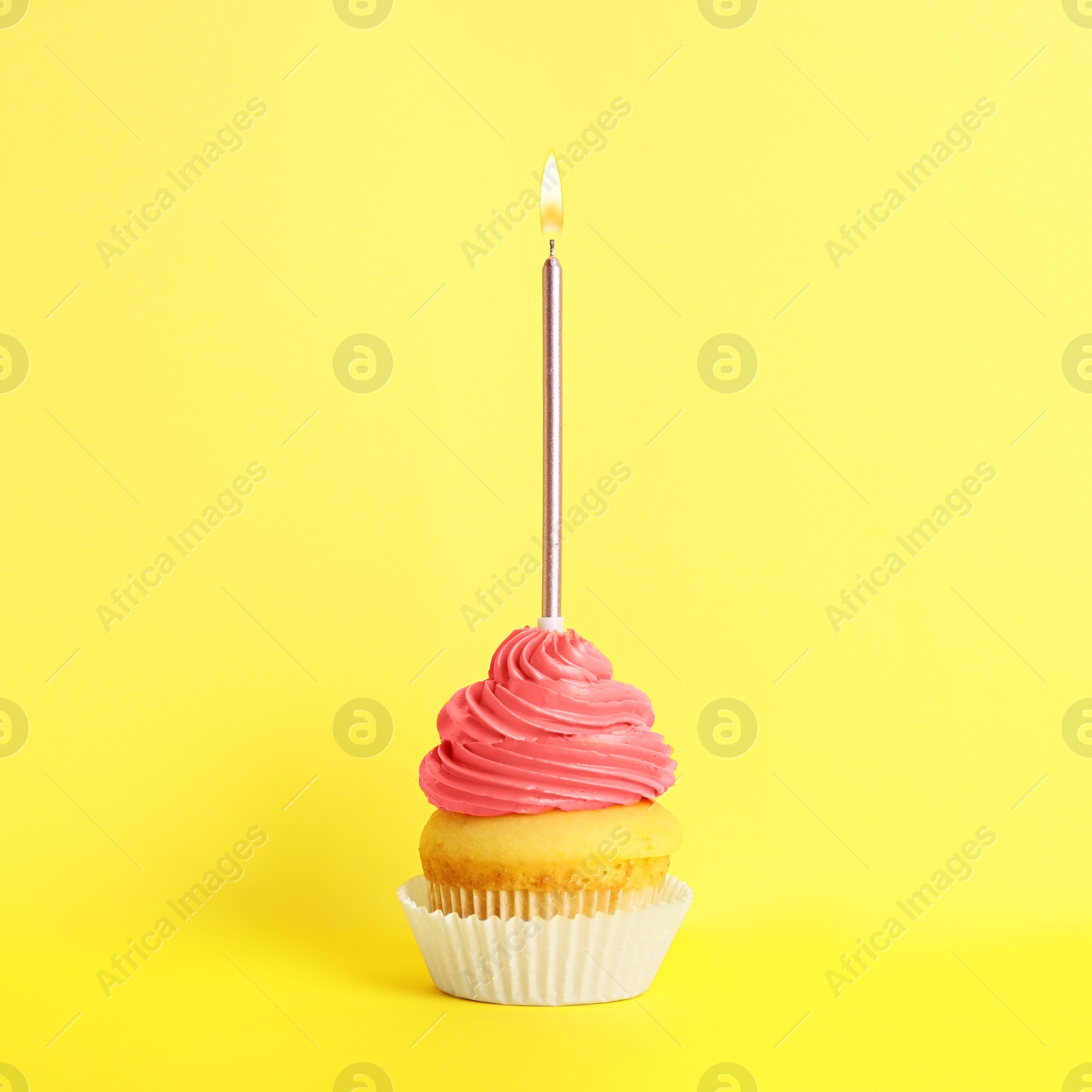 Photo of Birthday cupcake with candle on yellow background