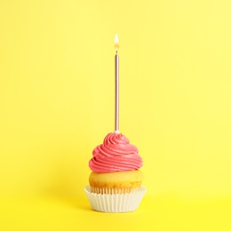 Photo of Birthday cupcake with candle on yellow background