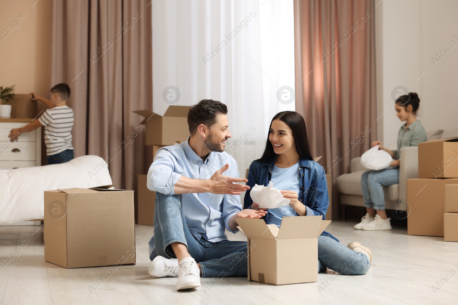 Photo of Happy family settling into new house and unpacking boxes. Moving day