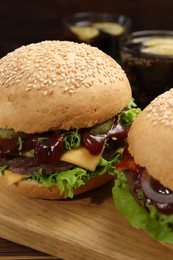 Board with delicious cheeseburgers on table, closeup