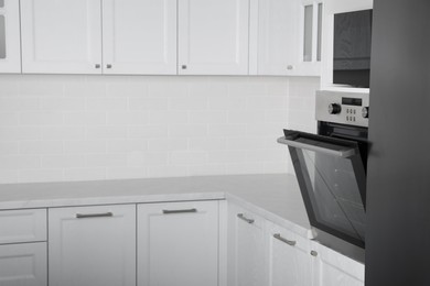 Photo of Modern oven and microwave in white clean kitchen