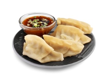 Photo of Delicious gyoza (asian dumplings) with sauce, onion and sesame isolated on white